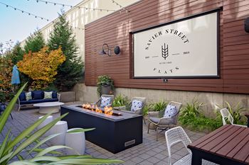 a backyard with a fire pit and a patio with chairs and a table